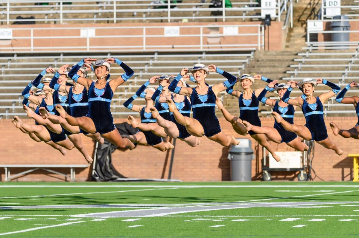 The Fillies leaping in the air during their performance at the Katy ISD Dance Invitational competition.